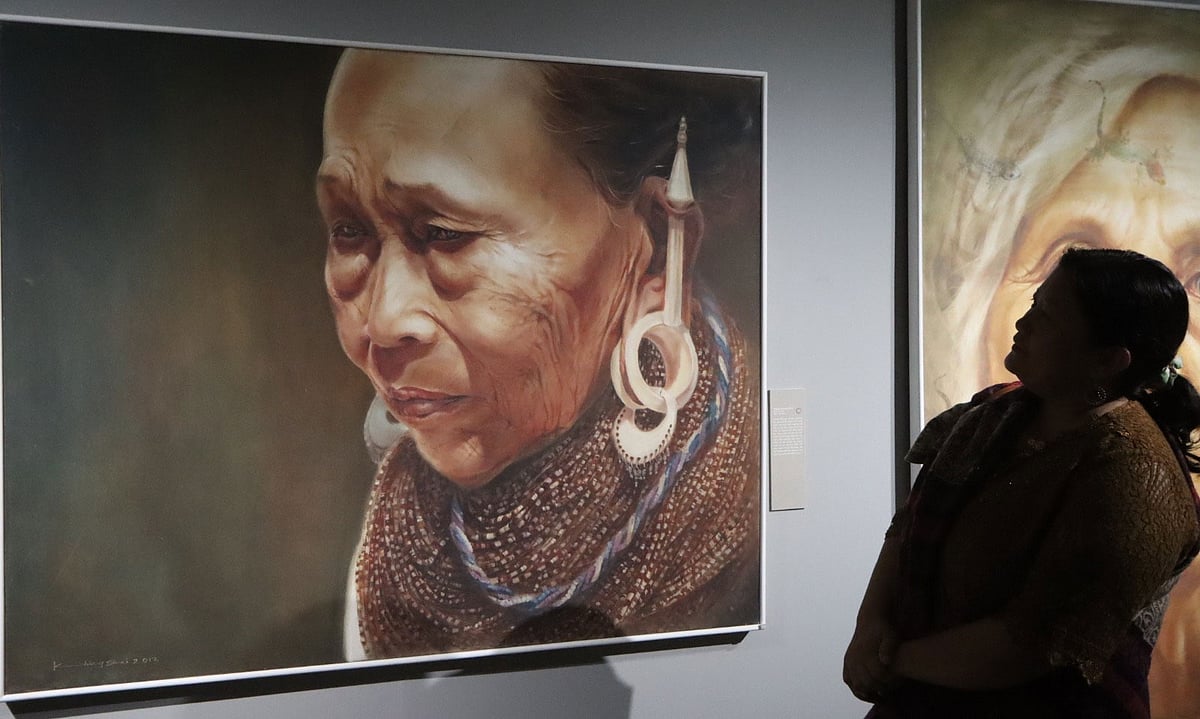 শিল্পী খিং সাই মং মারমার একক চিত্র প্রদর্শনীতে ছবি দেখছেন এক দর্শক। গত শুক্রবার বান্দরবানের ক্ষুদ্র নৃগোষ্ঠী সাংস্কৃতিক ইন্সটিটিউটে