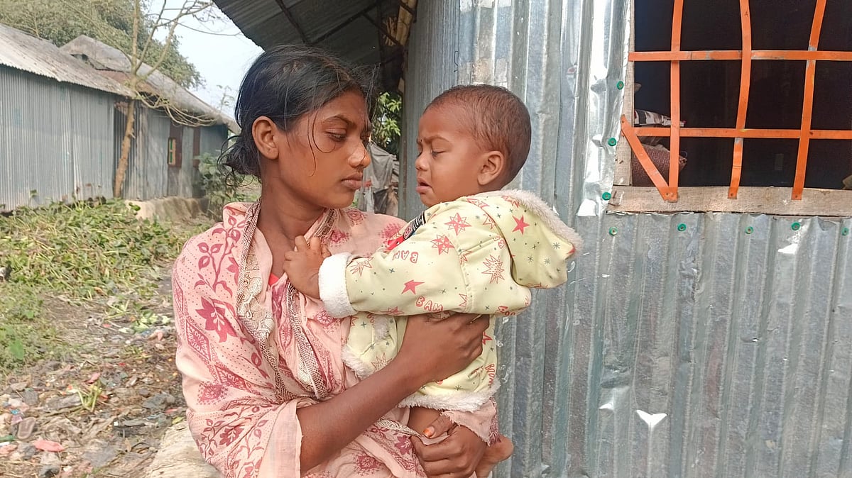 কোলের সন্তানের কান্না থামানোর চেষ্টা করছিলেন দীপু চন্দ্র দাসের স্ত্রী মেঘনা রানী রবিদাস। আজ বেলা ১১টার দিকে ময়মনসিংহের তারাকান্দা উপজেলার মোকামিয়াকান্দা গ্রামে