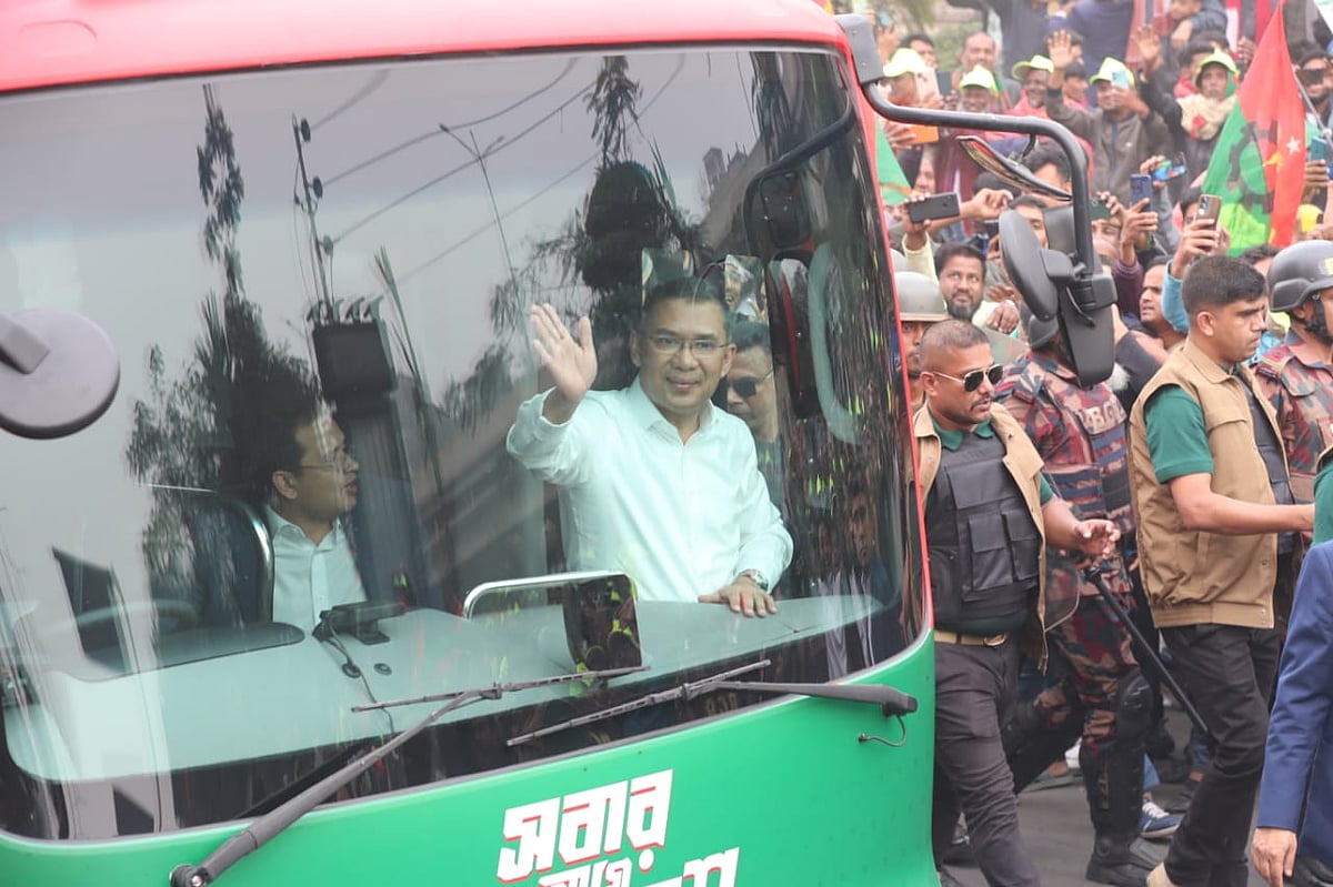 গণসংবর্ধনাস্থলের দিকে ধীরে ধীরে এগিয়ে যাচ্ছে তারেক রহমানকে বহনকারী বাস। এ সময় তিনি নেতা–কর্মীদের উদ্দেশে হাত নাড়েন 