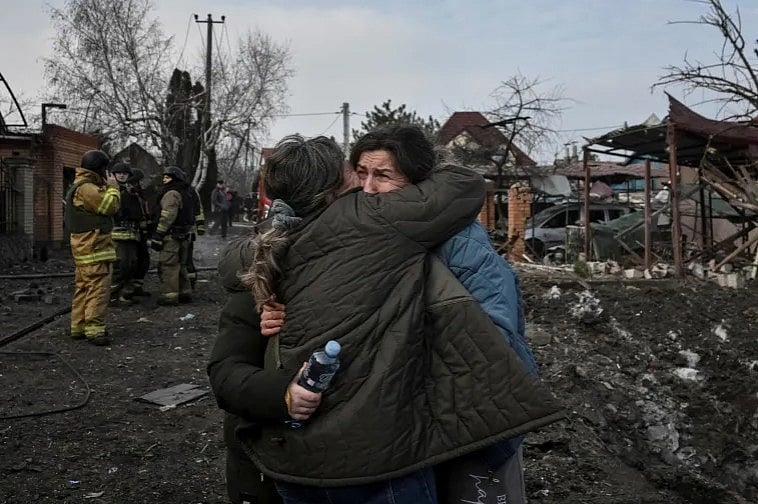 জাপোরিঝঝিয়াতে রাশিয়ার বিমান হামলায় বিধ্বস্ত একটি জায়গায় দাঁড়িয়ে স্থানীয় বাসিন্দারা একে অপরকে জড়িয়ে ধরে কাঁদছেন