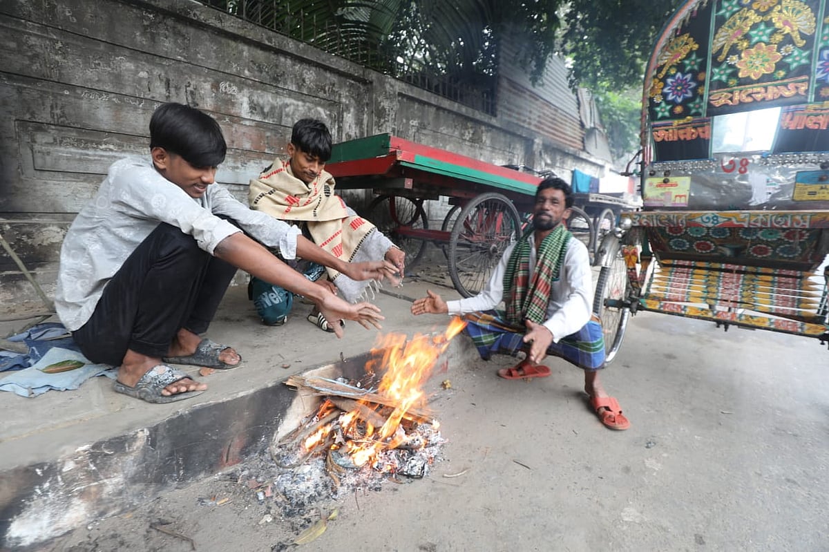 শীত নিবারণে আগুন পোহাচ্ছেন কয়েকজন। আজ সকালে নগরের খুলশীর আমবাগান এলাকায়