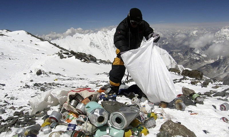 এভারেস্টে জমে থাকা আবর্জনা সংগ্রহ করছেন এক পর্বতারোহী