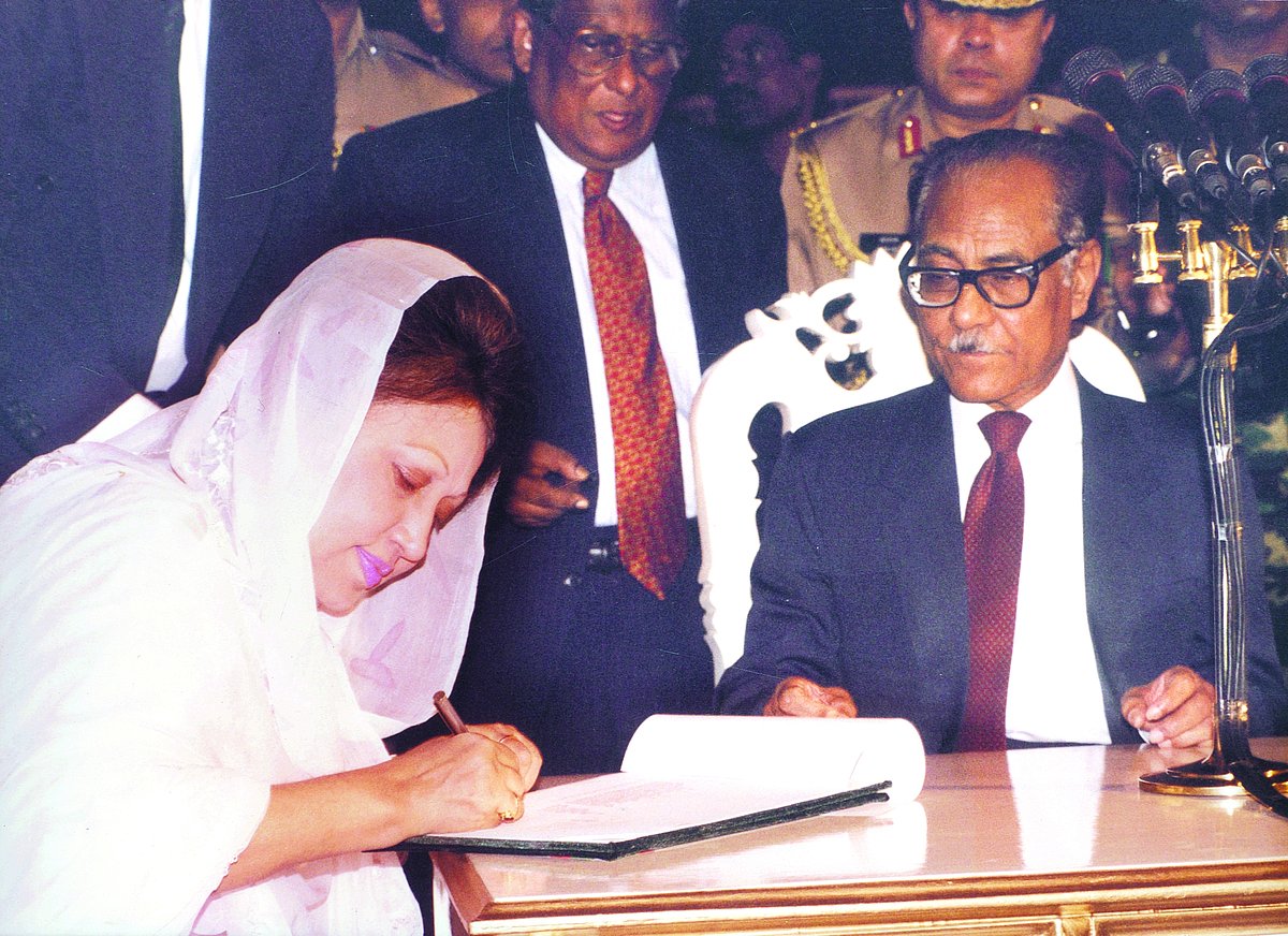 ১৯৯১ সালে প্রধানমন্ত্রী পদে শপথ নেওয়ার পর শপথ বইয়ে স্বাক্ষর করছেন খালেদা জিয়া। পাশে তৎকালীন রাষ্ট্রপতি বিচারপতি সাহাবুদ্দীন আহমদ