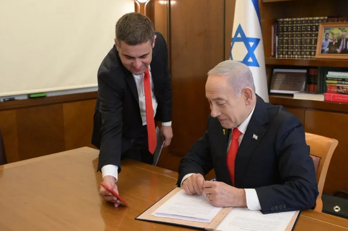 সোমালিল্যান্ডকে স্বীকৃতি দেওয়া–সংক্রান্ত নথিতে সই করছেন ইসরায়েলের প্রধানমন্ত্রী বেনিয়ামিন নেতানিয়াহু। তাঁকে মুঠোফোনে কিছু দেখাচ্ছেন ইসরায়েলের পররাষ্ট্রমন্ত্রী গিদিয়ন সার। ২৬ ডিসেম্বর ২০২৫