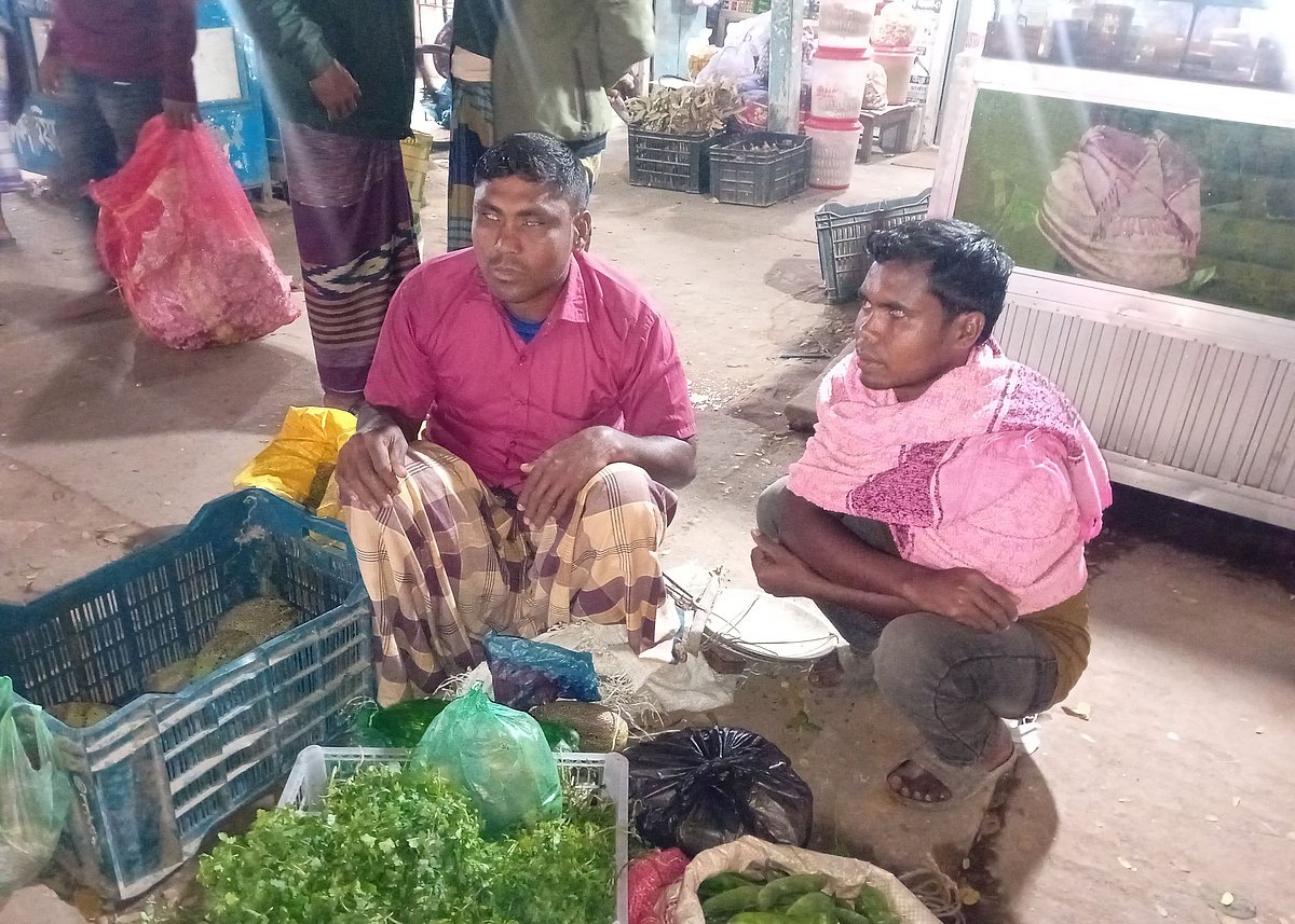 কনকনে ঠান্ডায় সড়কের পাশে বসে সবজি বিক্রি করছেন দুই সহোদর দৃষ্টিপ্রতিবন্ধী সুজন ও রাজন আহমদ। সম্প্রতি মৌলভীবাজারের জুড়ী উপজেলার ডাকঘর সড়ক এলাকায়