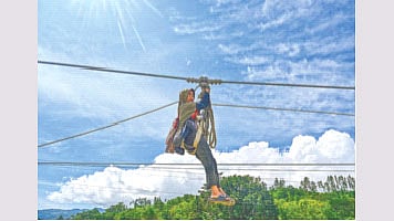 আকস্মিক বন্যায় বাসভবন প্লাবিত হলে একজন নারী নিরাপদ আশ্রয়ের জন্য তাঁর শিশুকে কোলে নিয়ে রশি ধরে নদী পার হচ্ছেন। গতকাল ইন্দোনেশিয়ার আচেহ প্রদেশে