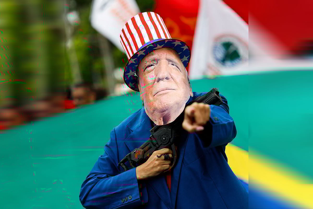 অস্ত্র হাতে ডোনাল্ড ট্রাম্প—এমন একটি ছবিসংবলিত মাস্ক পরে ভেনেজুয়েলার রাজধানী কারাকাসে বিক্ষোভে অংশ নেন এক মাদুরো–সমর্থক। ৫ জানুয়ারি ২০২৬, কারাকাস