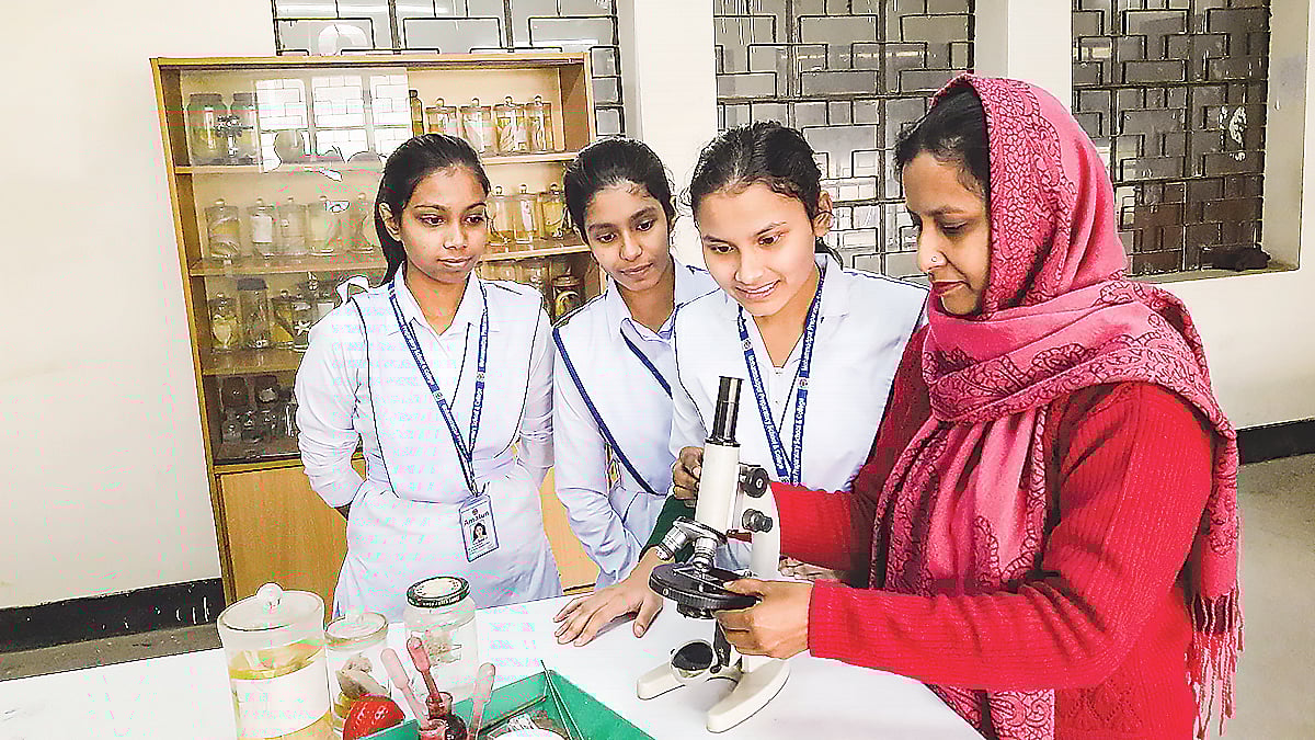 কলেজের ল্যাবটরিতে শিক্ষার্থীদের অনুবীক্ষণ যন্ত্র সম্পর্কে ধারণা দিচ্ছেন এক শিক্ষক
