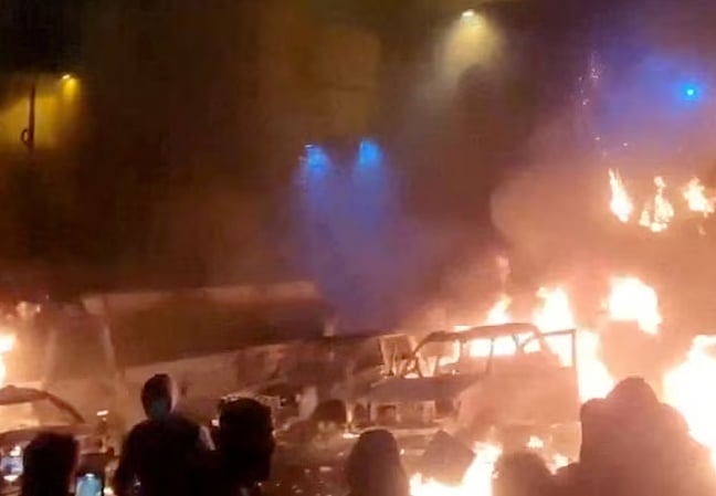 ইরানের তেহরানে সরকারবিরোধী বিক্ষোভ চলাকালে আগুন দেওয়া এক যানবাহনের সামনে বিক্ষোভকারীরা। সামাজিক যোগাযোগমাধ্যমে গত শুক্রবার ছড়িয়ে পড়া এই ভিডিও থেকে ছবি নেওয়া