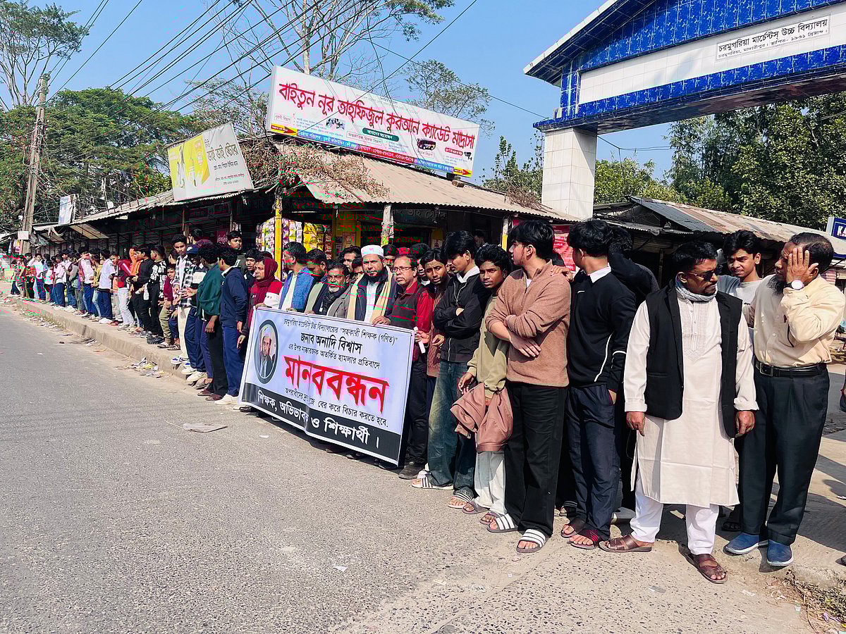 শিক্ষকের ওপর হামলার প্রতিবাদে শিক্ষক–শিক্ষার্থীদের মানববন্ধন। আজ সোমবার দুপুরে মাদারীপুর পৌর শহরের খাগদী-চরমুগরিয়া সড়কে