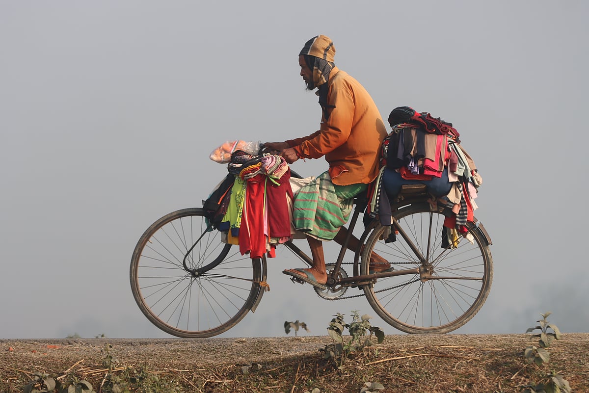 শীতের কাপড় বিক্রি করতে গ্রামের পথে সাইকেলে ঘুরছেন এই ব্যবসায়ী। ছবিটি নীলফামারীর কিশোরগঞ্জ উপজেলার গাড়াগ্রাম এলাকা থেকে তোলা। ১৩ জানুয়ারি