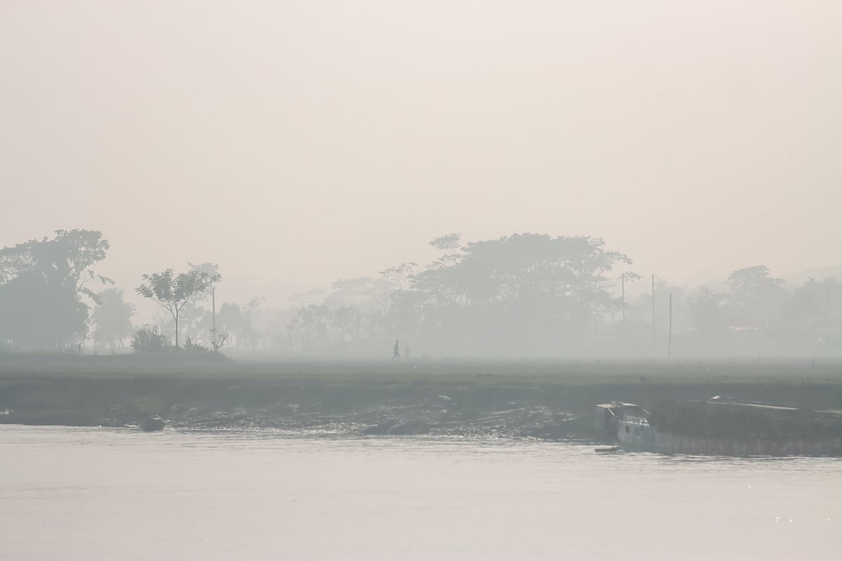 শীতের বিকেলে নদীর তীরে কুয়াশার মধ্যে হেঁটে যাচ্ছেন এক ব্যক্তি। গতকাল মঙ্গলবার তোলা। নরকাঠি, টুঙ্গিবাড়িয়া ইউনিয়ন, বরিশাল