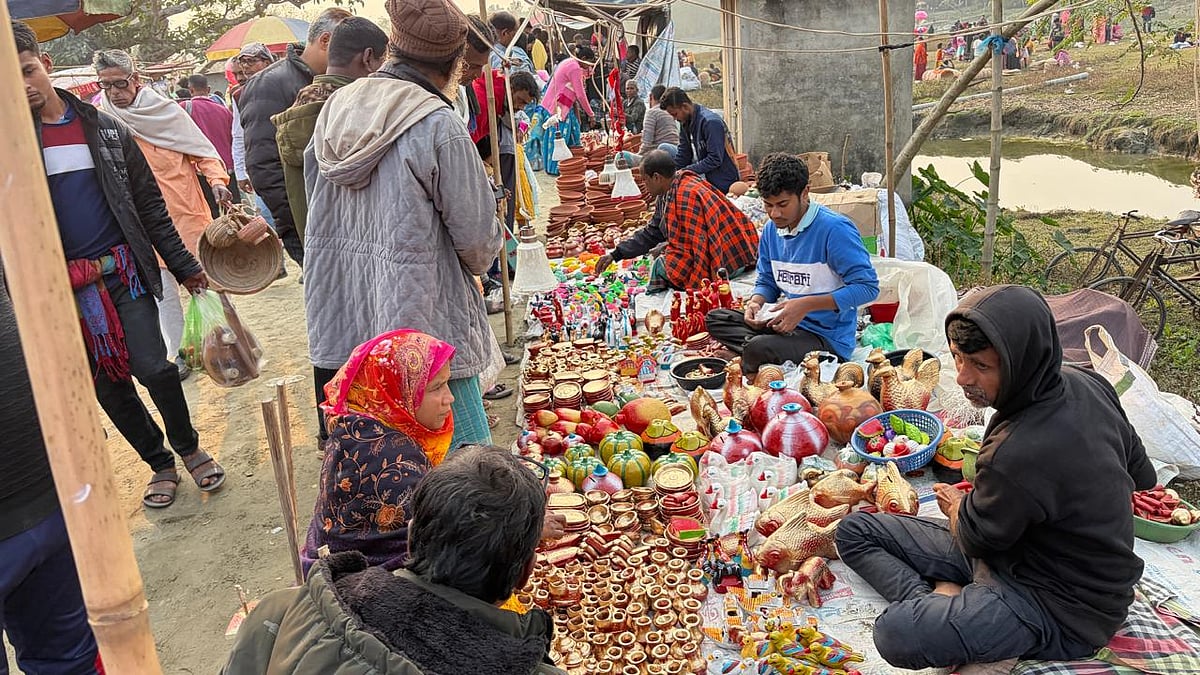 মেলায় মাটির তৈরি বিভিন্ন তৈজসপত্রের পসরা সাজিয়ে বসেছেন দোকানি। মেলায় আসা লোকজন কিনছেন সেসব  তৈজসপত্র
