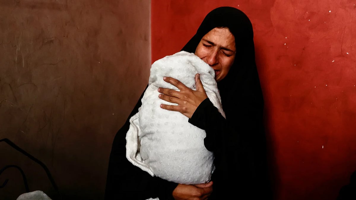 প্রচণ্ড জ্বর নিয়ে হাসপাতালে ভর্তি হওয়া তিন মাস বয়সী শাথা মারা গেছে। সন্তান হারানো মা হিবা আবু জারাদ যমজ মেয়ে নাদাকে বুকে জড়িয়ে কাঁদছেন। ২০ জানুয়ারি, ২০২৬, গাজা নগর