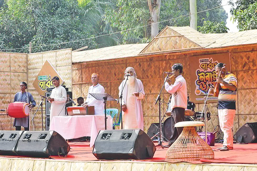 পার্বণ নবান্ন উৎসবে গান করছেন মানিকগঞ্জের প্রবীণ লোকসংগীতশিল্পী সাইদুর রহমান বয়াতি ও তাঁর দলের শিল্পীরা। গতকাল মানিকগঞ্জ পৌরসভার চর বেউথায় কালীগঙ্গা নদীর তীরে দ্য গার্ডেন টি হাব নামের আমবাগানে