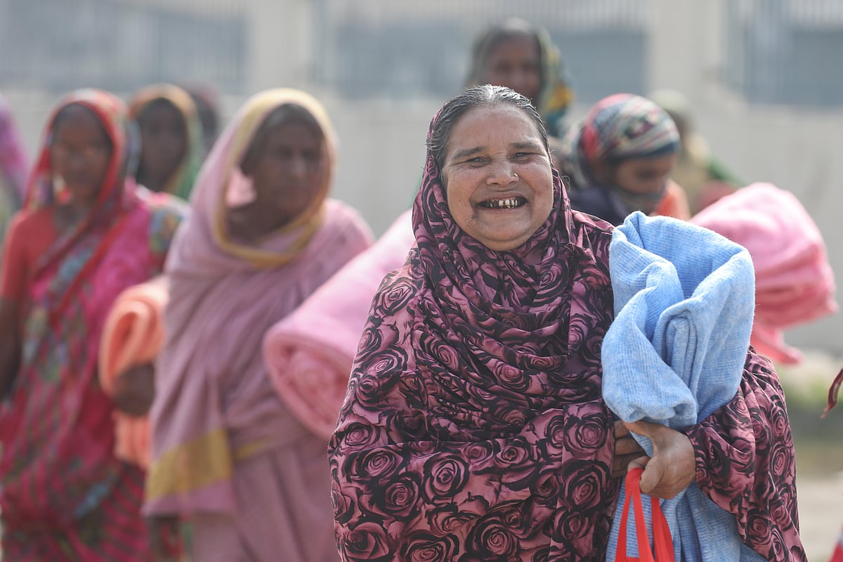 প্রথম আলো ট্রাস্টের পক্ষ থেকে কম্বল পেয়ে খুশি এক নারী। আজ রোববার খুলনার ডুমুরিয়া উপজেলার রায়েরমহল হামিদনগর হাজী মো. মুহসীন সরকারি প্রাথমিক বিদ্যালয় প্রাঙ্গণে