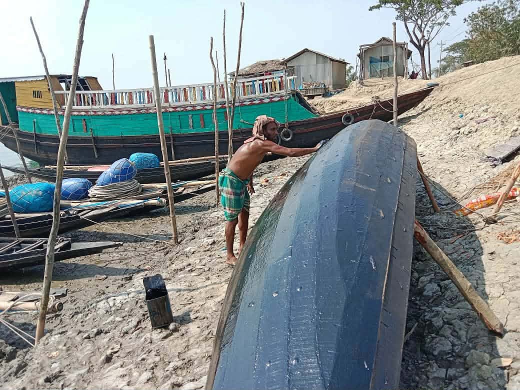 নৌকা ও অন্যান্য সরঞ্জাম ঠিক করতে ব্যস্ত জেলেরা। গতকাল শনিবার