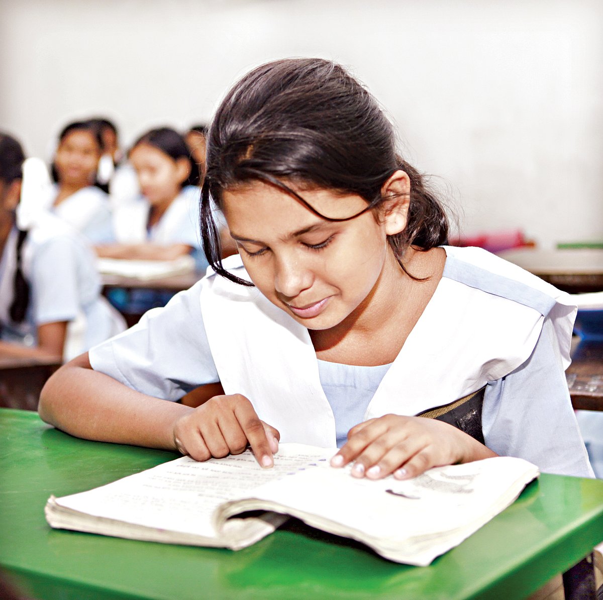 এক শিক্ষার্থী মনোযোগসহকারে শ্রেণিকক্ষে পাঠ্যবই পড়ছে