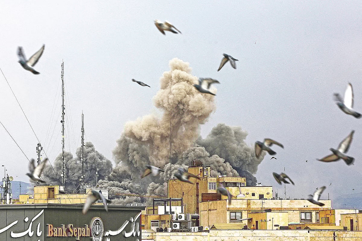 ইসরায়েল ও যুক্তরাষ্ট্রের যৌথ হামলার পর ধোঁয়ার বিশাল কুণ্ডলী। বিস্ফোরণের বিকট শব্দে আতঙ্কিত হয়ে উড়ে যাচ্ছে পাখি। গতকাল ইরানের রাজধানী তেহরানে