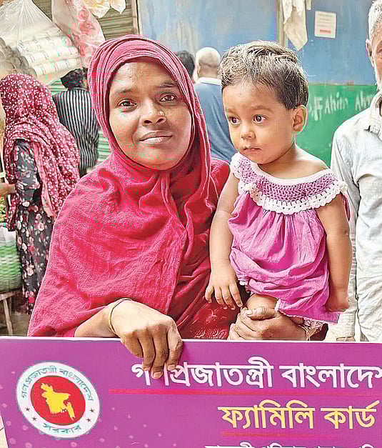 প্রধানমন্ত্রীর কাছ থেকে নেওয়া ফ্যামিলি কার্ড হাতে বাক্‌প্রতিবন্ধী সমলা। গতকাল কড়াইল বস্তি এলাকায়