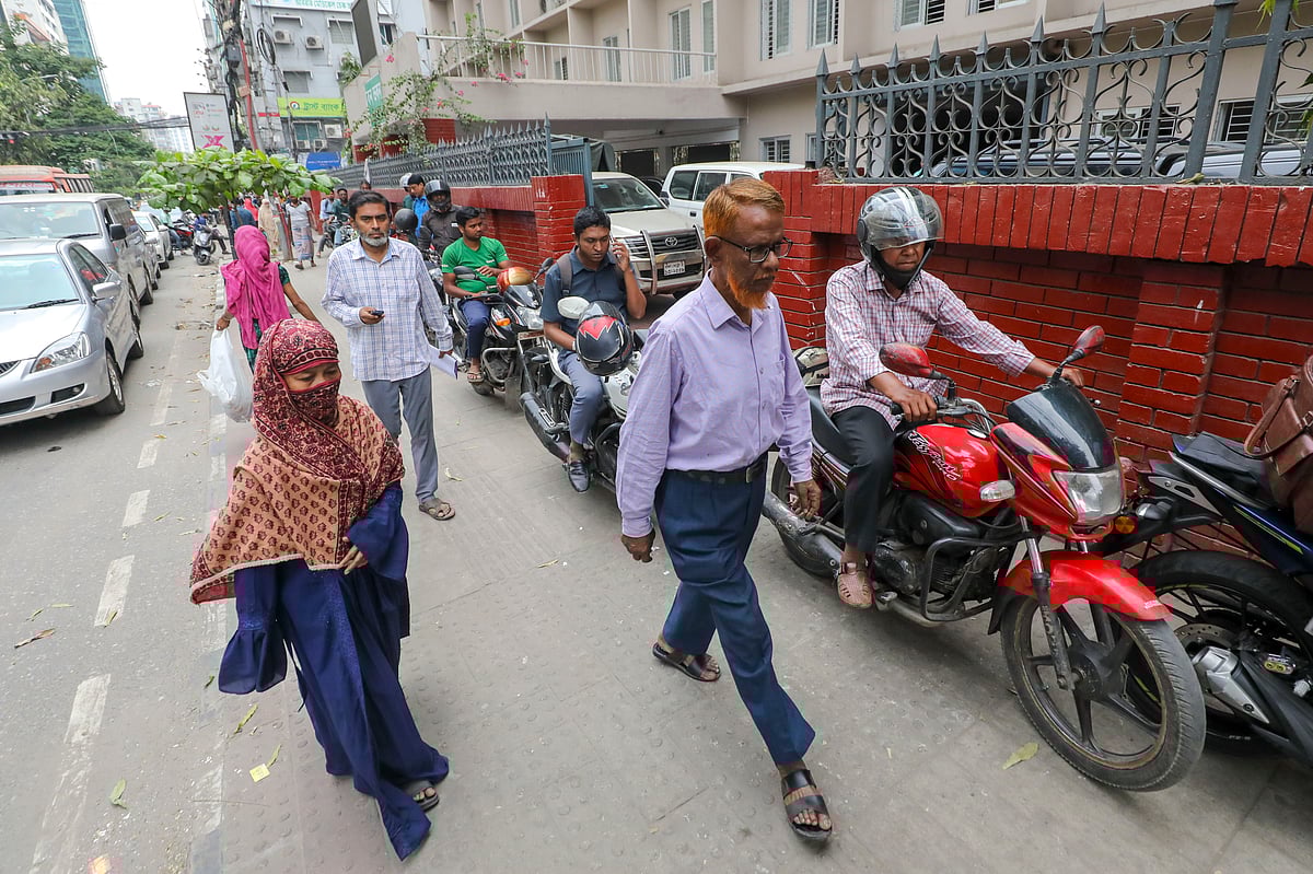 রাজধানীর মহাখালী এলাকায় তেল নিতে মোটরসাইকেলের চালকেরা ফুটপাতে উঠে লাইন ধরেছেন। ১২ মার্চ ২০২৬