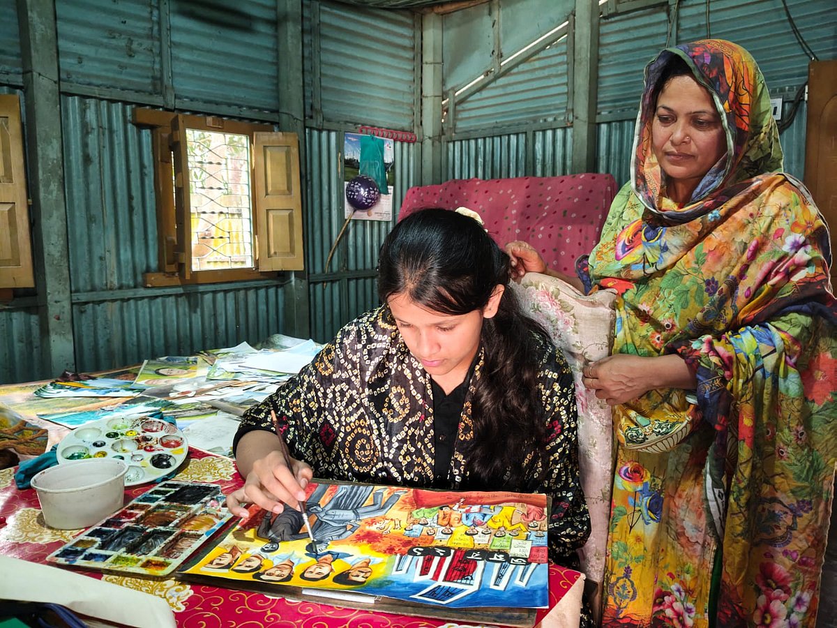 ছবি আঁকায় নিমগ্ন ময়মনসিংহের মুক্তাগাছার বাক্‌ ও শ্রবণপ্রতিবন্ধী কিশোরী সাবা ইসলাম। পাশে দাঁড়িয়ে মা। ৬ মার্চ দুপুরে তোলা