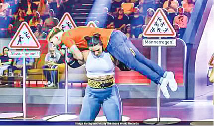 এক পুরুষকে কাঁধের ওপর তুলে ছুড়ে ফেলছেন জিনা রুপেনটাল