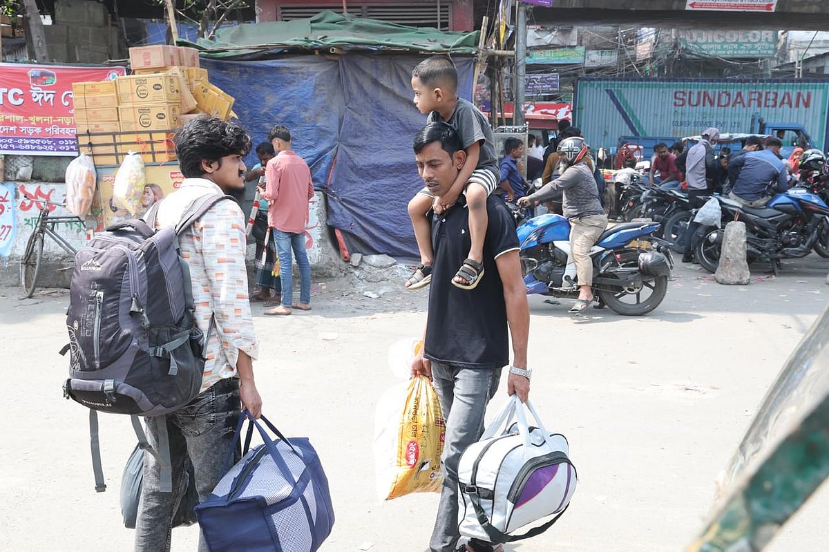 শিশুকে কাঁধে ও দুই হাতে দুই ব্যাগ নিয়ে ঈদযাত্রার প্রস্তুতি। আজ মঙ্গলবার সকালে রাজধানীর যাত্রাবাড়ীতে