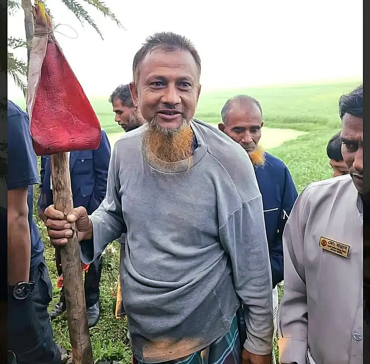 কলার মোচা থেকে লাল রঙের বড় খোসা খুলে লাঠির মাথায় দড়ি দিয়ে বাঁধেন দিনমজুর এনামুল হক। এটা দিয়েই তিনি ট্রেন থামান