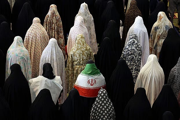 গায়ে জাতীয় পতাকা জড়িয়ে ঈদের জামাতে ইরানি নারী। গ্র্যান্ড মোসাল্লা মসজিদ, তেহরান, ২১ মার্চ ২০২৬