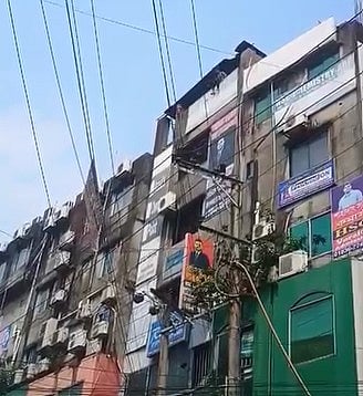 লাফ দেওয়ার আগে বিপণিবিতানের ছাদে ওই তরুণ। আজ সকালে