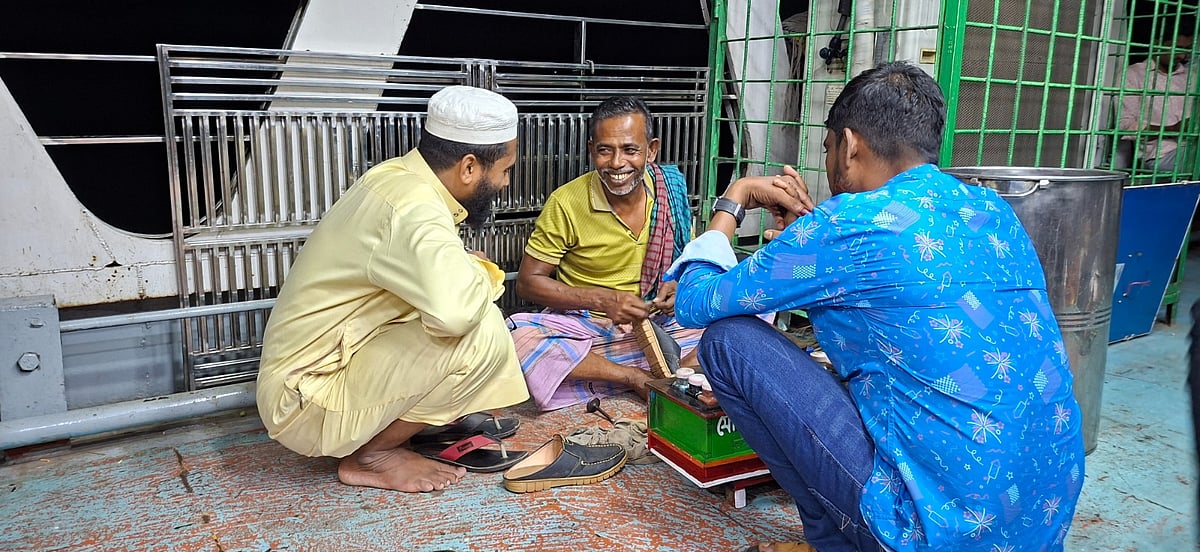 হাসিমুখে এক যাত্রীর জুতা মেরামত করছেন বাবুল হোসেন। গত মঙ্গলবার রাতে বরিশাল নদীবন্দরে একটি লঞ্চে