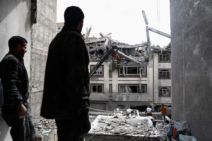 ছবিতে দেখা যাচ্ছে, এক ব্যক্তি ইরানের রাজধানী তেহরানে একটি আবাসিক ভবনের ধ্বংসাবশেষ দেখছেন