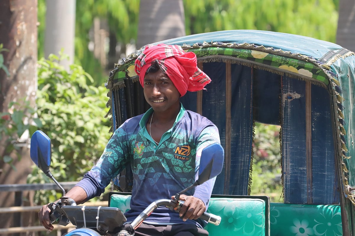 গরমে মাথায় গামছা বেঁধে রিকশা চালাচ্ছেন এক চালক। ৩ এপ্রিল, রাজশাহী