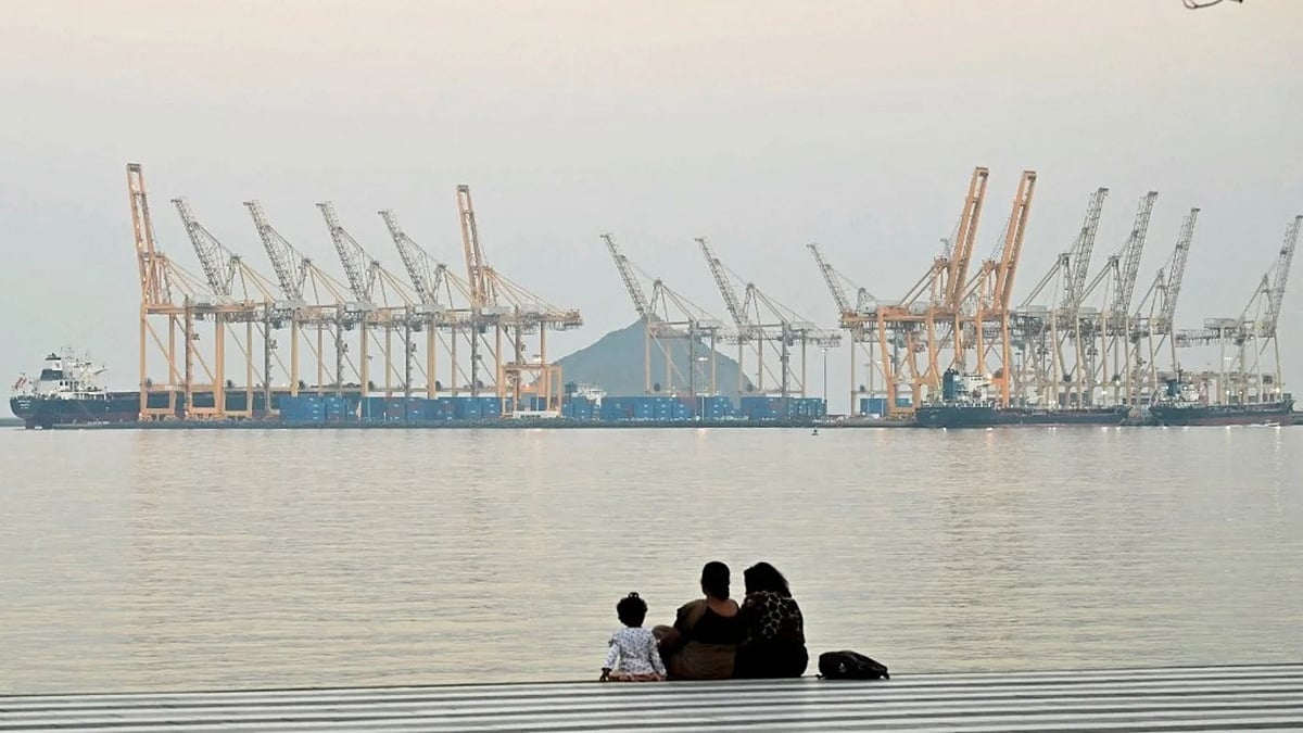 ওমান উপসাগর উপকূলে আমিরাতের শারজাহর খোর ফাক্কান ডকইয়ার্ডের পটভূমিতে বসে আছে একটি পরিবার। ২৫ ফেব্রুয়ারি ২০২৬