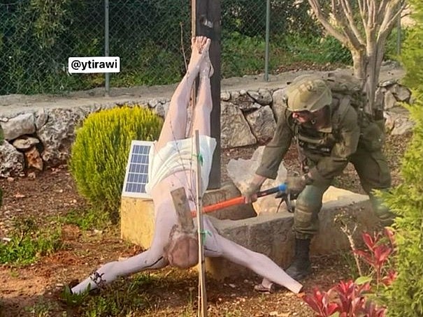 বড় একটি হাতুড়ি দিয়ে যিশুর মূর্তির মাথায় আঘাত করা হচ্ছে