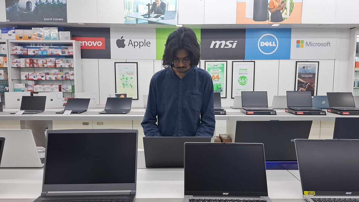 ঢাকার একটি কম্পিউটারের বাজারে ল্যাপটপ দেখছেন একজন ক্রেতা