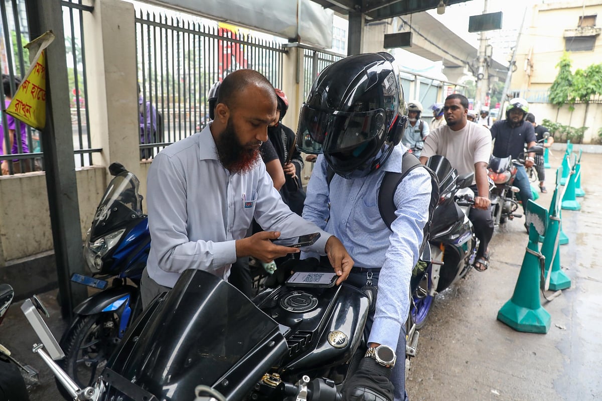 কমেছে জ্বালানি তেল নেওয়ার দীর্ঘ লাইন। ফুয়েল পাস দেখিয়ে তেল নিচ্ছেন চালকেরা। আজ বুধবার রাজধানীর পরীবাগ এলাকায়