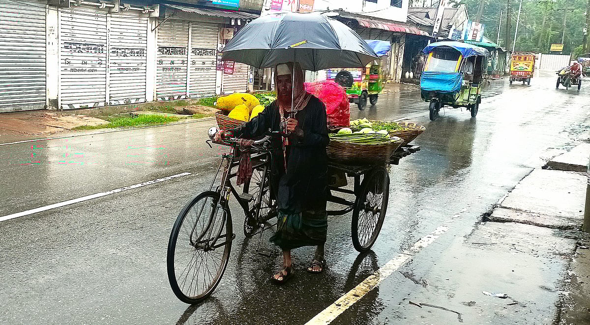বৃষ্টিতে ভিজে ভিজে সবজি বিক্রি করছিলেন বৃদ্ধ হেলাল উদ্দিন। আজ বুধবার সকালে জামালপুর শহরের বানিয়া বাজার এলাকায়