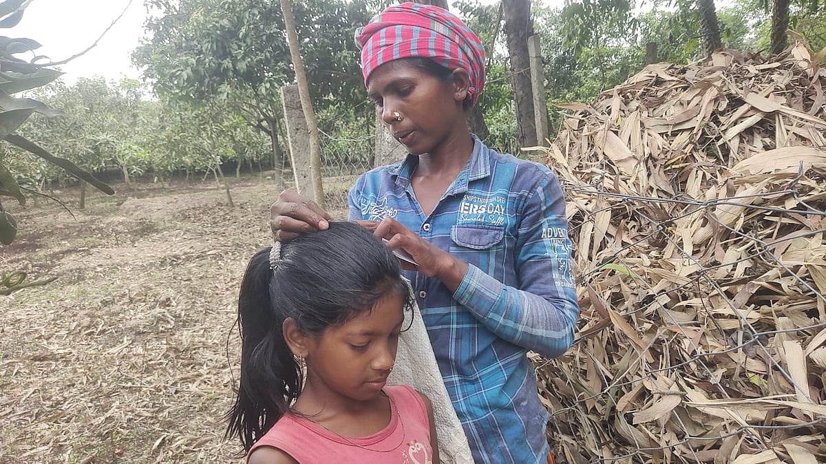 মেয়ের মাথায় আদুরে বিলি কাটছেন নীলা হাসদা। সম্প্রতি চাঁপাইনবাবগঞ্জের নাচোল উপজেলার বীরগঞ্জে