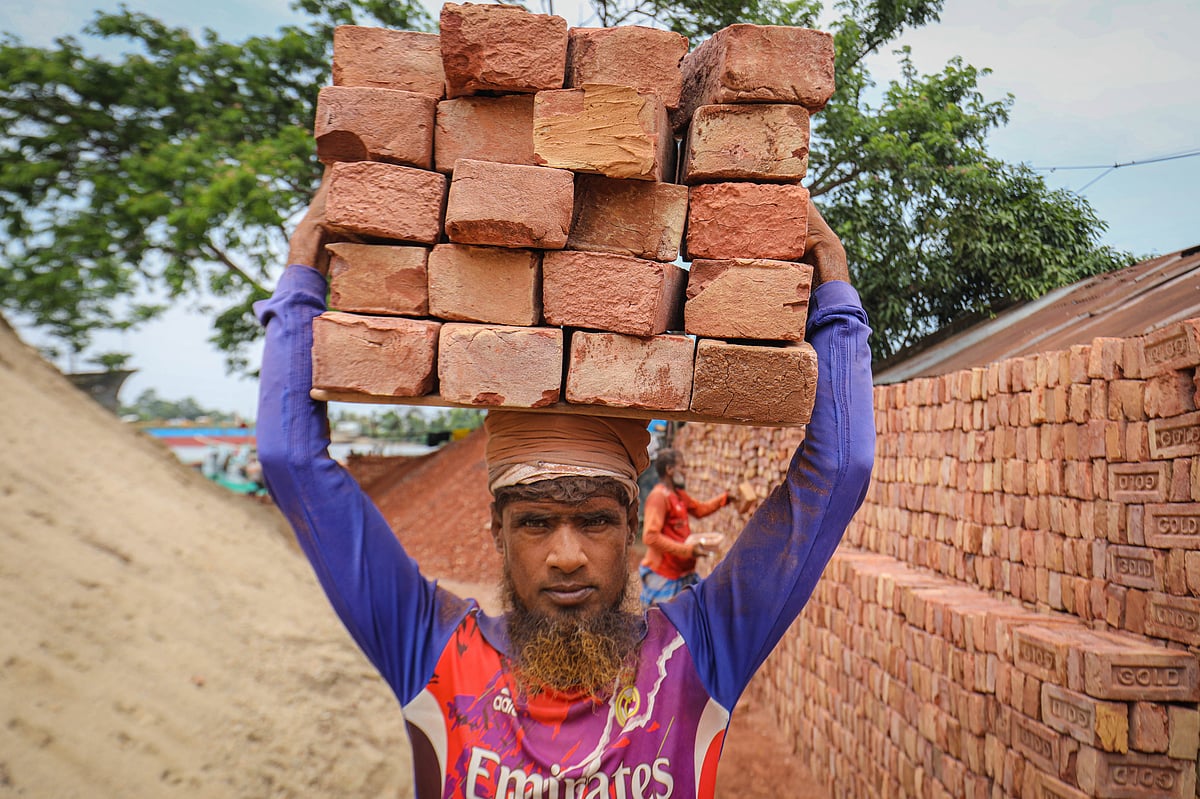 ইটের বোঝা মাথায় নিয়ে যাচ্ছেন এক শ্রমিক