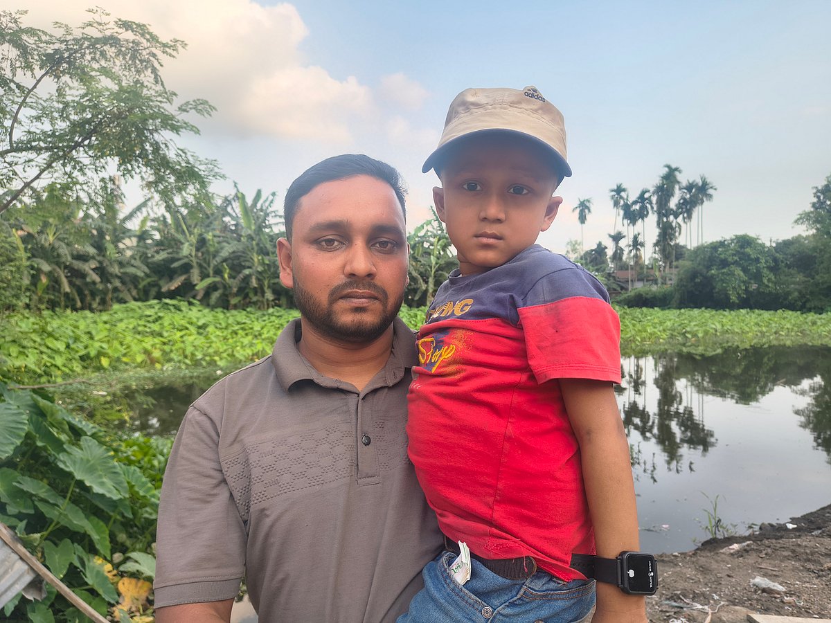 বাবা মিজানুর রহমানের কোলে শিশু ফাহিম। সোমবার কুড়িগ্রামের রাজারহাট উপজেলার রেলগেট এলাকায়