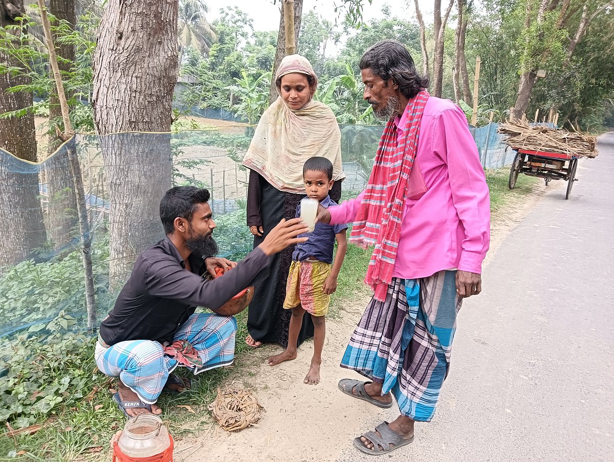 রাজবাড়ী-বালিয়াকান্দি সড়কের রাস্তার ধারে এভাবেই তালের রস বিক্রি করছেন স্থানীয় অনেক বাসিন্দা। গরমে তৃষ্ণা মেটাতে পরিবারের সদস্যদের সঙ্গে তালের রস পান করছেন এক ব্যক্তি