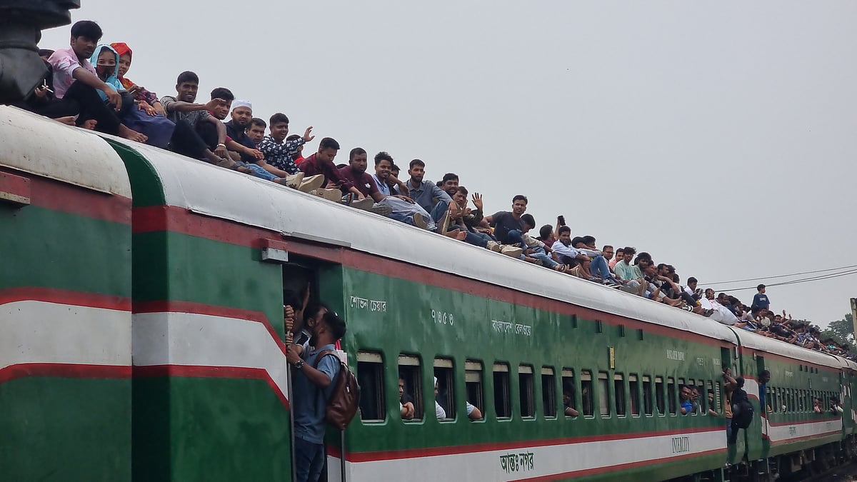 রাজধানীর কমলাপুর রেলওয়ে স্টেশনে বনলতা এক্সপ্রেসের ছাদে যাত্রীদের ভিড়। অনেকেই যাচ্ছেন দরজায় ঝুলে। আজ মঙ্গলবার দুপুরে
