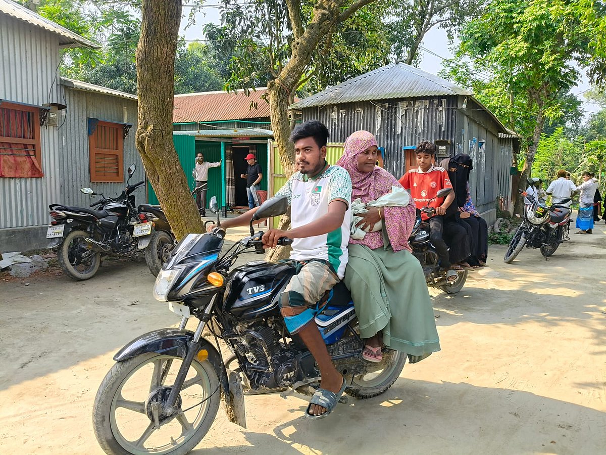 সদ্যোজাত সন্তানকে নিয়ে মোটরসাইকেলে চড়ে বাড়ি ফিরছেন মা মুর্শিদা (পেছনের মোটরসাইকেলে) ও তাঁর পরিবারের সদস্যরা