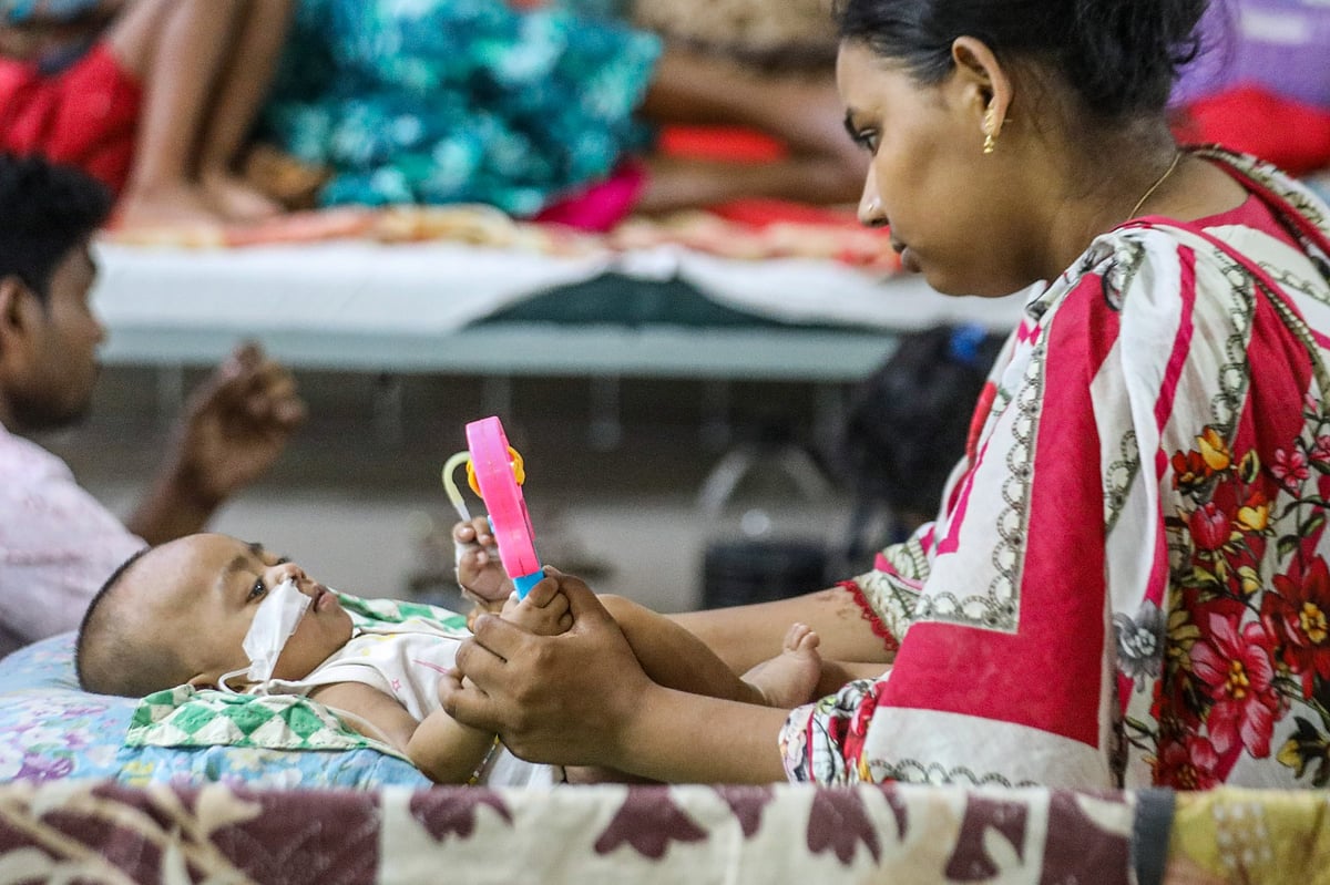 হামে আক্রান্ত শিশুরা বাংলাদেশ শিশু হসপিটালে চিকিৎসাধীন। এক শিশুকে খেলনা দিয়ে স্বস্তি দেওয়ার চেষ্টা করছেন এক অভিভাবক। গতকাল শুক্রবার দুপুরে