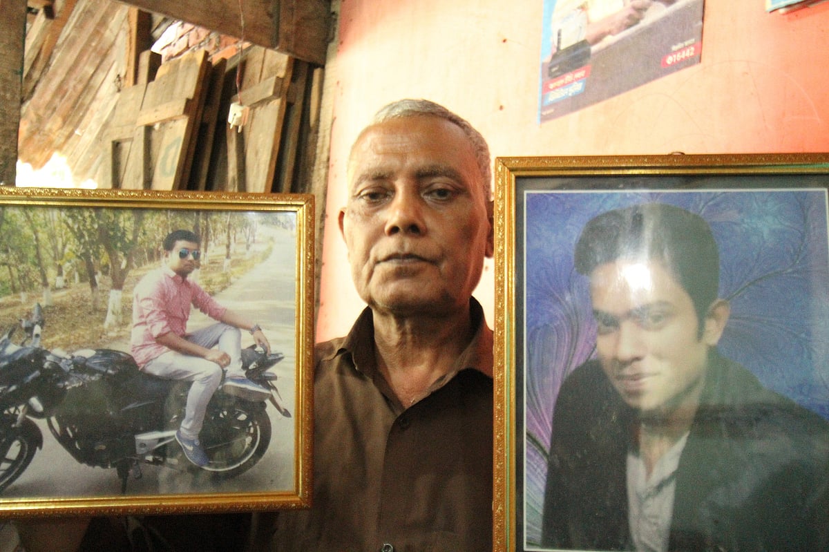 পাহাড়ধসে নিহত দুই ছেলের ছবি হাতে বাদল দত্ত। গতকাল শুক্রবার রাঙামাটির ভেদাভেদী এলাকায়