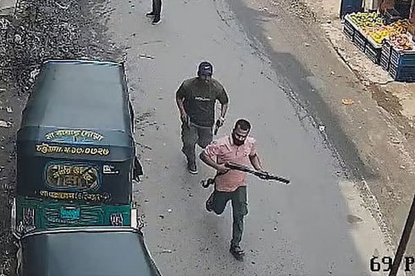 অস্ত্র হাতে দুই সন্ত্রাসী। চট্টগ্রামের রাউজানের পাহাড়তলীর চৌমুহনী বাজারে। ১৩ জুন বেলা দেড়টার দিকে