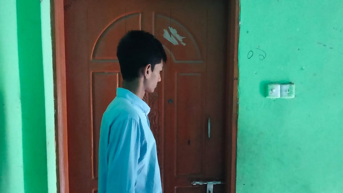 তালা বন্ধ ঘরের সামনে নির্বাক দাঁড়িয়ে জুনায়েদ ইসলাম সিফাত। লক্ষ্মীপুরের রায়পুর পৌর শহরের ধানহাটায় গতকাল দুপুরে