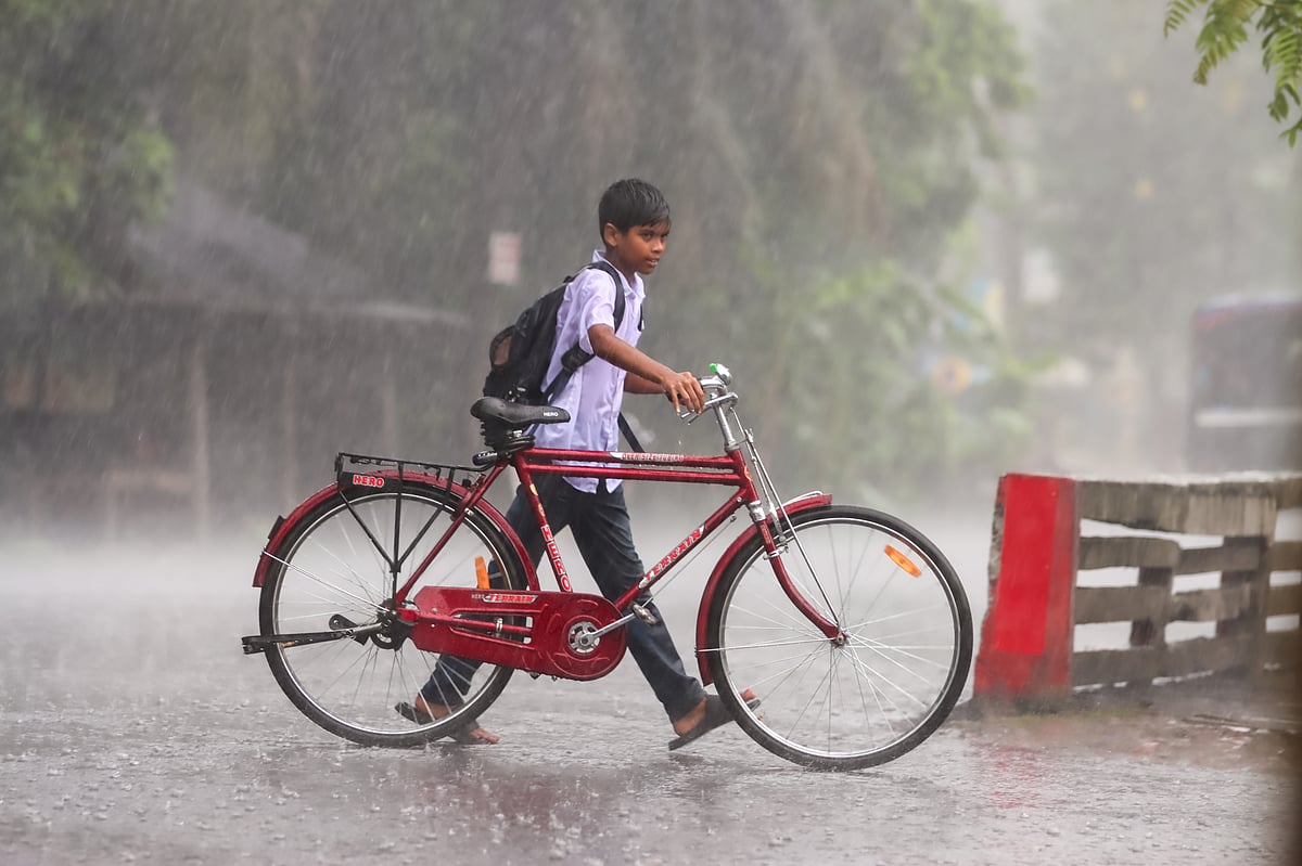 ভারী বৃষ্টির মধ্যে ক্লাস শেষে বিদ্যালয় থেকে সাইকেল নিয়ে গন্তব্যে ফিরছে এক শিক্ষার্থী। ছয়মাইল, কাশিপুর, বরিশাল, ১ জুলাই